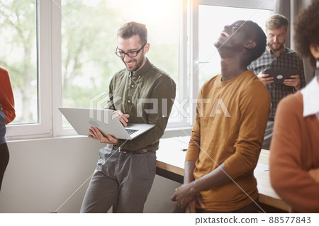 cheerful young employees standing near a table in a coworking ce cheerful young employees standing near a table in a coworking ce 88577843