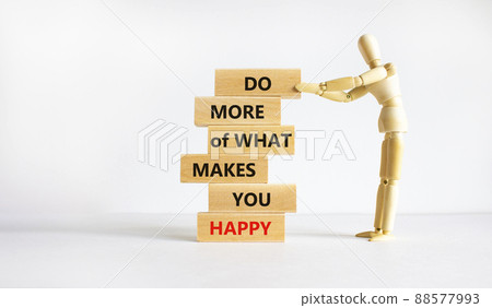 Do what makes you happy symbol. Wooden blocks with words 'Do more of what makes you happy'. Businessman model. Beautiful white background, copy space. Business, do what makes you happy concept. Do what makes you happy symbol. Wooden blocks with words 'Do more of what makes you happy'. Businessman model. Beautiful white background, copy space. Business, do what makes you happy concept. 88577993