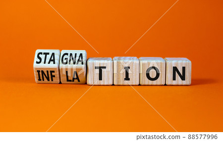 Inflation and stagnation symbol. Turned wooden cubes and changed the word inflation to stagnation. Beautiful orange table, orange background, copy space. Business, inflation and stagnation concept. 88577996