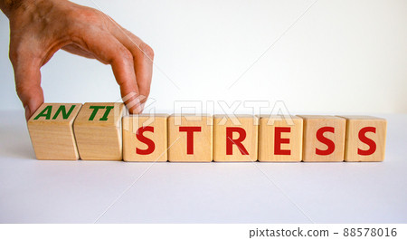 Antistress vs stress symbol. Doctor turns cubes and changes the word stress to anti stress. Beautiful white table, white background. Medical, psychological, antistress vs stress concept. Copy space. Antistress vs stress symbol. Doctor turns cubes and changes the word stress to anti stress. Beautiful white table, white background. Medical, psychological, antistress vs stress concept. Copy space. 88578016