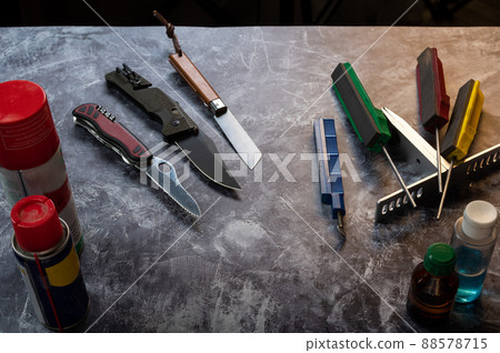 Several knives are on the table. Various knives on the table. Knives and tools on the table. Knife workshop. Several knives are on the table. Various knives on the table. Knives and tools on the table. Knife workshop. 88578715