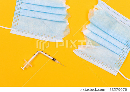Broken Medical Syringe and Torn Medical Face Mask Broken Medical Syringe and Torn Medical Face Mask 88579076