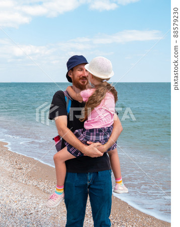 Happy family father daughter hugging on marine landscape. Bearded dad with child in hands having fun together 88579230