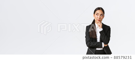Smart professional female architect, industrial woman in suit thinking about solution, looking upper left corner and touching chin thoughtful, making-up plan, standing white background 88579231
