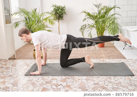 Mature man doing yoga exercise at home. Health care online lessons. Indoor Mature man doing yoga exercise at home. Health care online lessons. Indoor 88579716