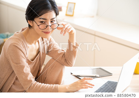 一名穿著室內服裝並使用電腦的年輕女子 88580470