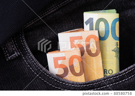 Folded US dollars sharpen from the pocket of blue jeans. Folded US dollars sharpen from the pocket of blue jeans. 88580758