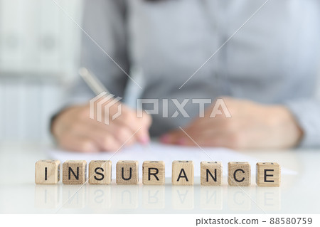 Insurance agent fills out insurance form in office closeup Insurance agent fills out insurance form in office closeup 88580759