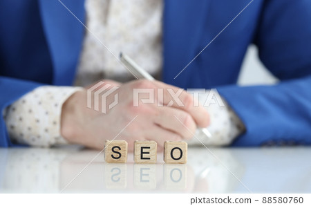 Seo manager in business suit at table with pen Seo manager in business suit at table with pen 88580760