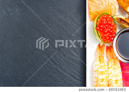 traditional japanese sushi set on a white plate on a black stone. tasty set of sushi, nigiri, sahimi and maki. delicious dinner or lunch for one person. flat lay 88581065