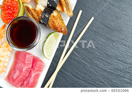 traditional japanese sushi set on a white plate on a black stone. tasty set of sushi, nigiri, sahimi and maki. delicious dinner or lunch for one person. flat lay traditional japanese sushi set on a white plate on a black stone. tasty set of sushi, nigiri, sahimi and maki. delicious dinner or lunch for one person. flat lay 88581066