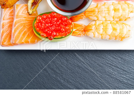 traditional japanese sushi set on a white plate on a black stone. tasty set of sushi, nigiri, sahimi and maki. delicious dinner or lunch for one person. flat lay traditional japanese sushi set on a white plate on a black stone. tasty set of sushi, nigiri, sahimi and maki. delicious dinner or lunch for one person. flat lay 88581067