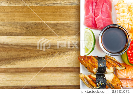 traditional japanese sushi set on a white plate with wood background. tasty set of sushi, nigiri, sahimi and maki. delicious dinner or lunch for one person. flat lay traditional japanese sushi set on a white plate with wood background. tasty set of sushi, nigiri, sahimi and maki. delicious dinner or lunch for one person. flat lay 88581071