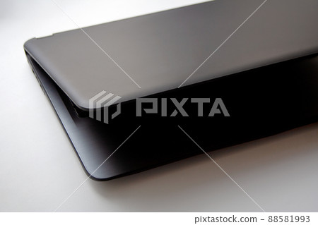 Left side detail of half closed slate grey laptop on white background Left side detail of half closed slate grey laptop on white background 88581993