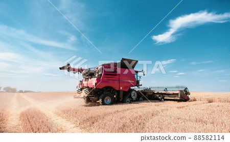 Combine harvester on grain field during harvest time Combine harvester on grain field during harvest time 88582114