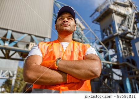 Experienced worker standing in front of large concrete plant Experienced worker standing in front of large concrete plant 88583811