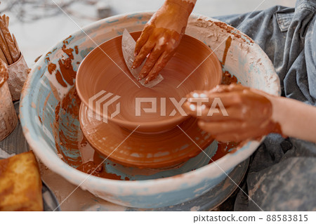 Artisan hands working on pottery wheel with ceramics Artisan hands working on pottery wheel with ceramics 88583815
