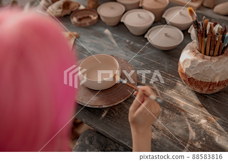 Young female potter engaged in craft in her workshop Young female potter engaged in craft in her workshop 88583816