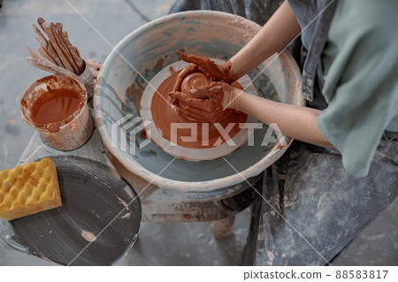 Clay artist modeling product on potter wheel in workshop Clay artist modeling product on potter wheel in workshop 88583817