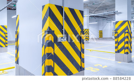 Empty shopping mall underground parking lot or garage interior with concrete stripe painted columns Empty shopping mall underground parking lot or garage interior with concrete stripe painted columns 88584228