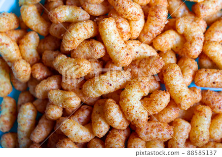 Puffed corn peanuts snacks on plate. Close-up. Puffed corn peanuts snacks on plate. Close-up. 88585137