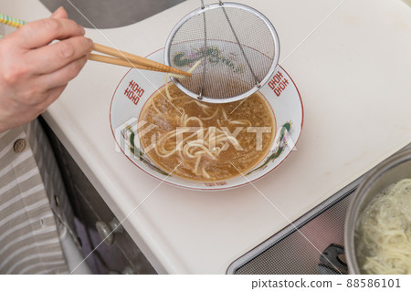 [Middle housewife puts boiled ramen noodles in a bowl] 88586101
