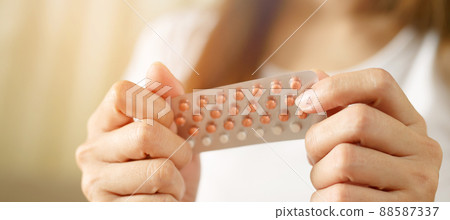 Woman hands opening birth control pills in hand. eating Contraceptive pill. Contraception reduces childbirth and pregnancy concept. Leave space to write descriptive text. 88587337
