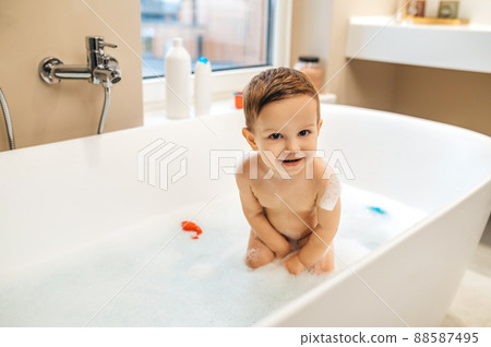Cheerful child posing for the camera in the bathroom 88587495
