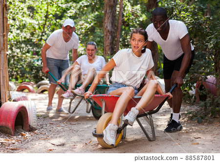 Men drive their girls in garden wheelbarrows. Funny amusement park amusement park 88587801