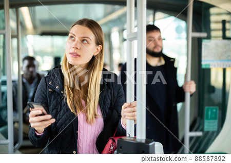 Young woman with phone in streetcar 88587892