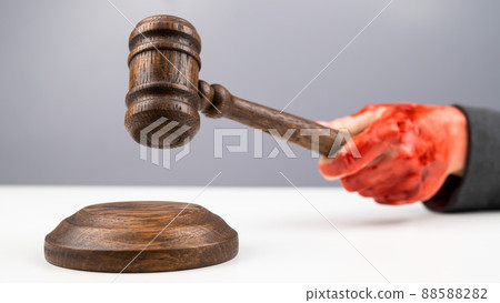 Female judge with bloody hands beats the gavel on a white background. 88588282