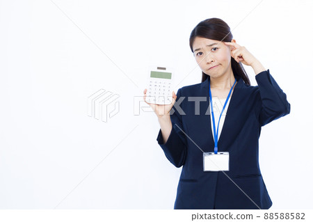 Business woman in her thirties with a calculator 88588582