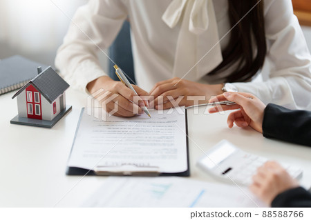 Close up of Business woman pointing and signing agreement for buying house. Bank manager concept. Close up of Business woman pointing and signing agreement for buying house. Bank manager concept. 88588766