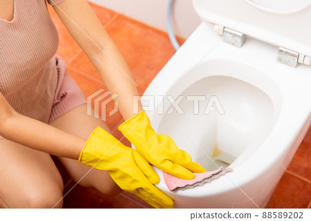 Hands of Asian woman cleaning toilet seat by pink cloth wipe restroom at house Hands of Asian woman cleaning toilet seat by pink cloth wipe restroom at house 88589202