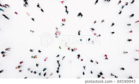 Aerial Drone View Over many people skating on an open-air ice rink in winter. Aerial Drone View Over many people skating on an open-air ice rink in winter. 88590043