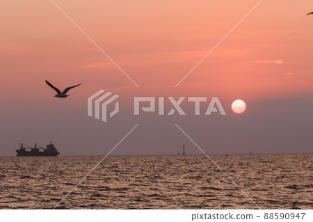 The landscape on a clear sky day will see a beautiful sunset slowly sliding down above the sea surface. It's a beautiful sight to see. The landscape on a clear sky day will see a beautiful sunset slowly sliding down above the sea surface. It's a beautiful sight to see. 88590947