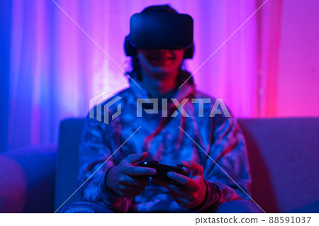 Metaverse technology concept, Man wear VR goggles and use joystick to play sport games in metaverse 88591037