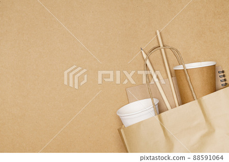 Eco friendly concept, notebook pencil and paper cup with straws in paper bag on wooden background Eco friendly concept, notebook pencil and paper cup with straws in paper bag on wooden background 88591064