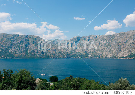 Motor boat sails through the turquoise waters of the Bay of Kotor Motor boat sails through the turquoise waters of the Bay of Kotor 88592190