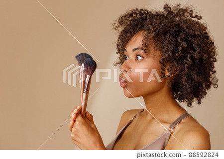 Young woman with cosmetic brushes in studio 88592824