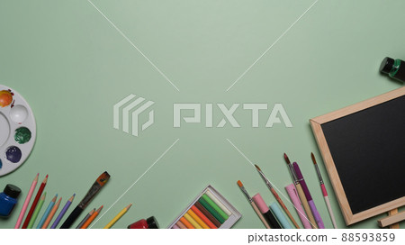 Chalkboard and school stationery on green background. Back to school concept. Chalkboard and school stationery on green background. Back to school concept. 88593859