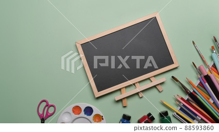 Empty chalkboard and stationery on green background. Back to school concept. Empty chalkboard and stationery on green background. Back to school concept. 88593860