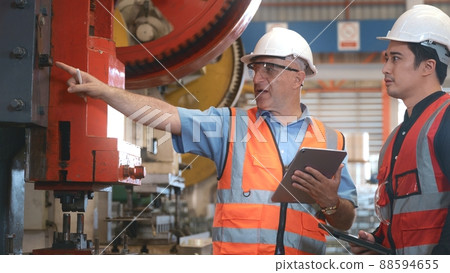 Engineer teaching apprentice to use metal sheet stamping machine Engineer teaching apprentice to use metal sheet stamping machine 88594655
