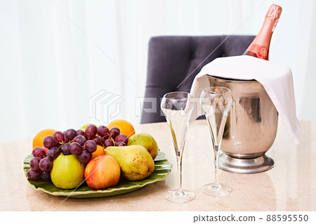 Champagne in a Hotel Room, Ice Bucket, Glasses and Fruits on a Plate - Honeymoon Concept Champagne in a Hotel Room, Ice Bucket, Glasses and Fruits on a Plate - Honeymoon Concept 88595550