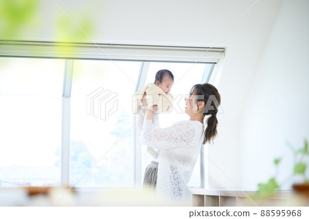Mom raising baby high in a bright room Mom raising baby high in a bright room 88595968