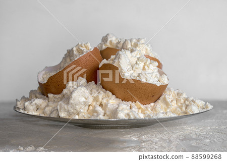 Egg protein powder on a plate and egg shells. Sports nutrition. 88599268