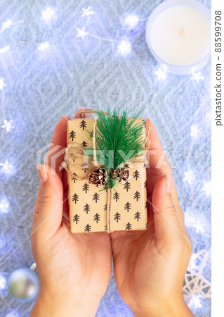Womans hands hold a small christmas gift 88599708