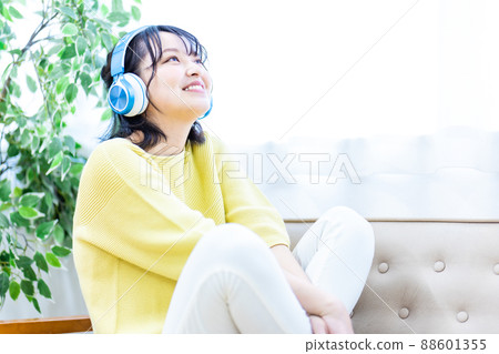 Young woman listening to music with headphones Young woman listening to music with headphones 88601355