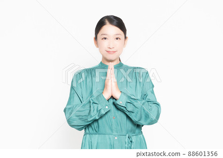 A housewife who asks you to put your palms together in front of a white background A housewife who asks you to put your palms together in front of a white background 88601356