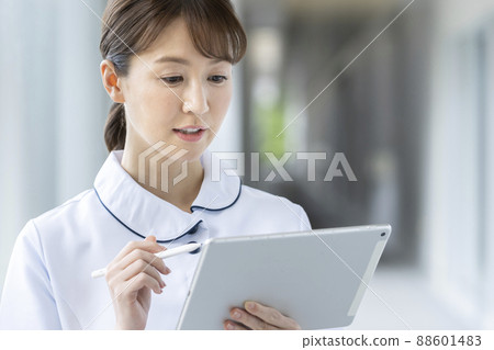一位身穿白大褂、手持平板電腦的女醫務工作者的形象 88601483